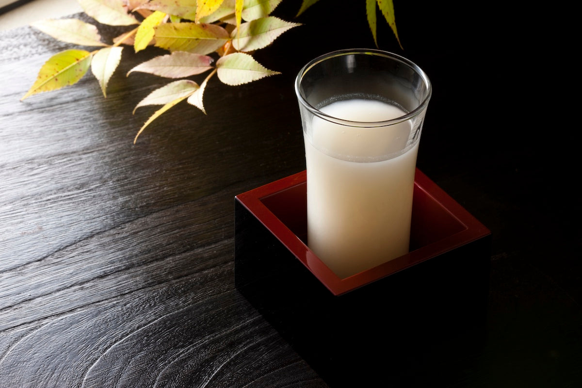 shot glass of cloudy sake in a masu